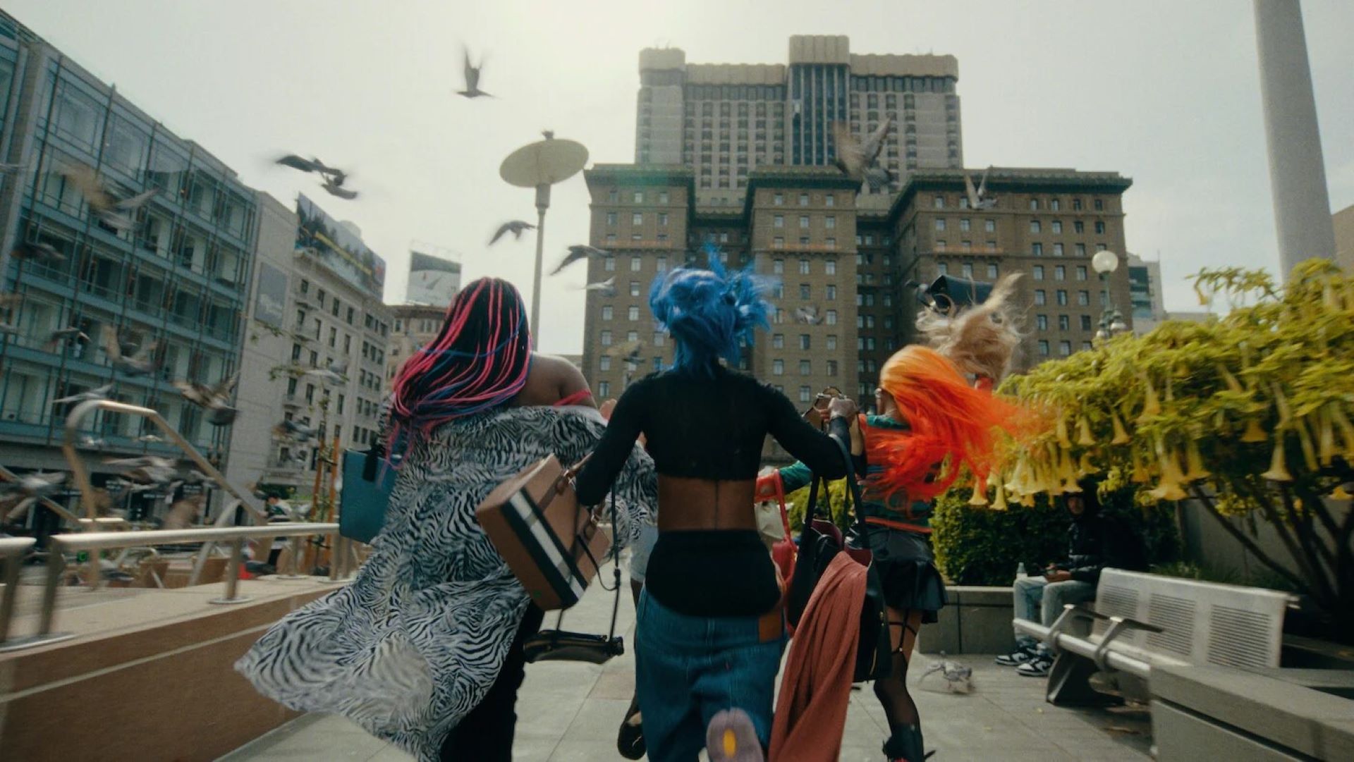 Three Rainbow Girls (Tati, Angel, and Gemini) carrying bags of stolen goods race through a flock of pigeons in San Francisco's Union Square.