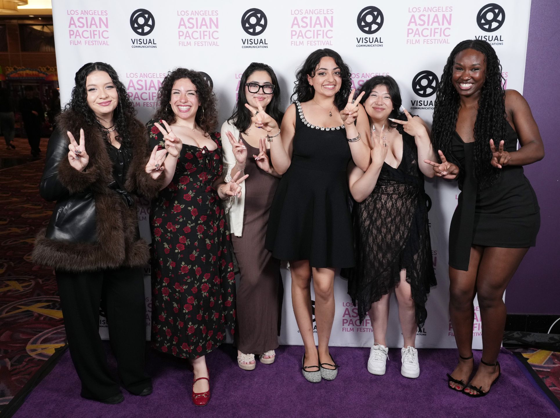 Two QWOCMAP Filmmakers Anushka Shah and Danna Kim from the film Home Visit pose with a group